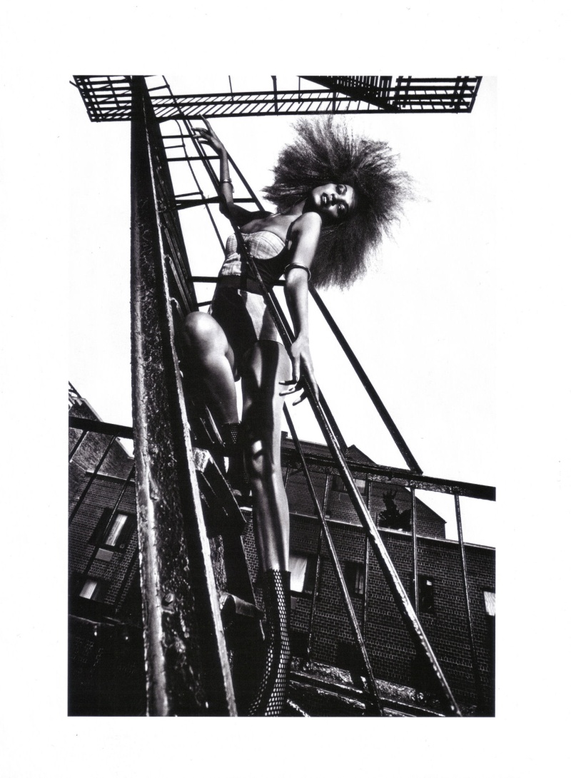 A black and white photo of a woman on a ladder.