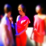 A blurry image of a group of women at a fashion show.