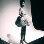 A woman in a dress posing in a studio.