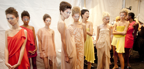 A group of women in colorful dresses standing in a line.