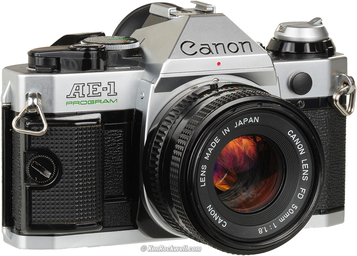 A silver canon camera with a lens attached.