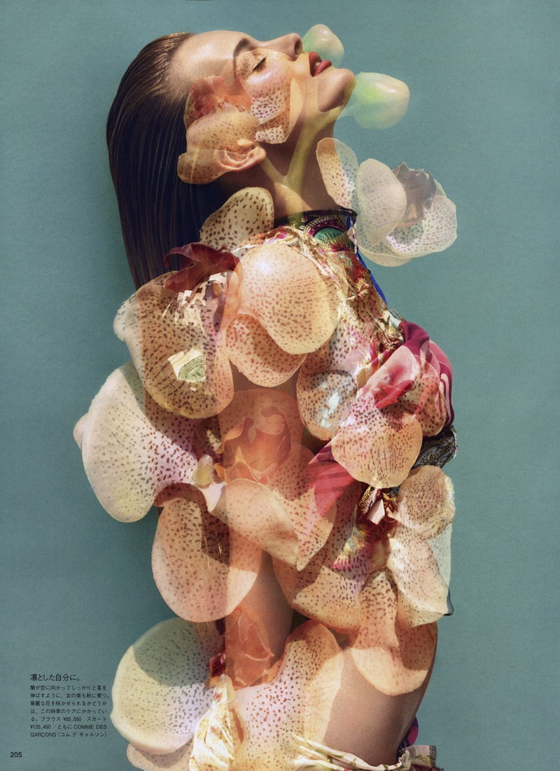 An image of a woman posing with flowers on her head.