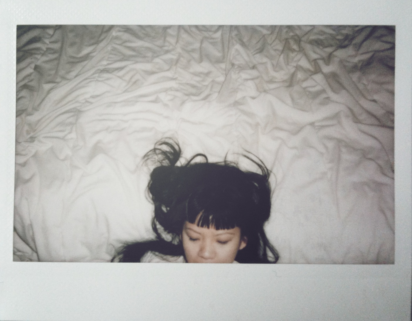 A girl laying on a bed with black hair.