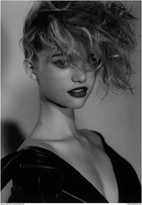 A black and white photo of a woman with curly hair.