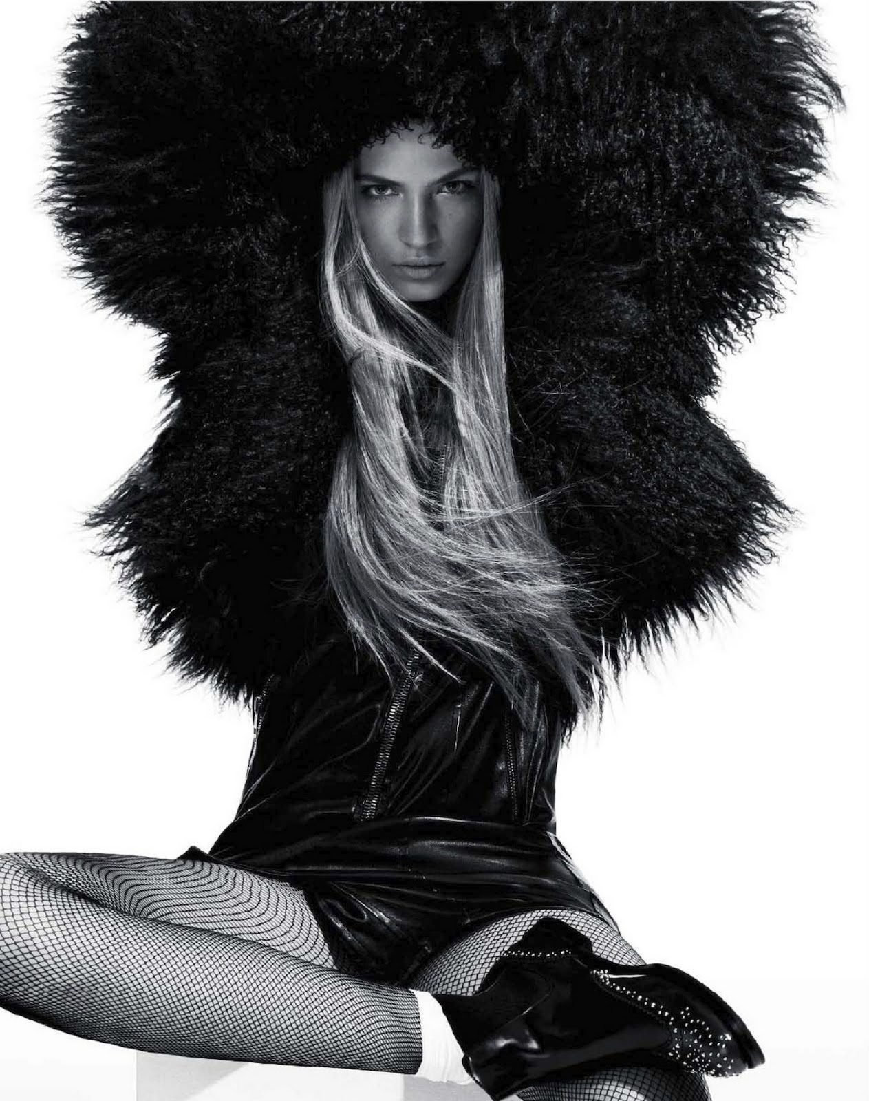 A black and white photo of a woman wearing a fur coat.