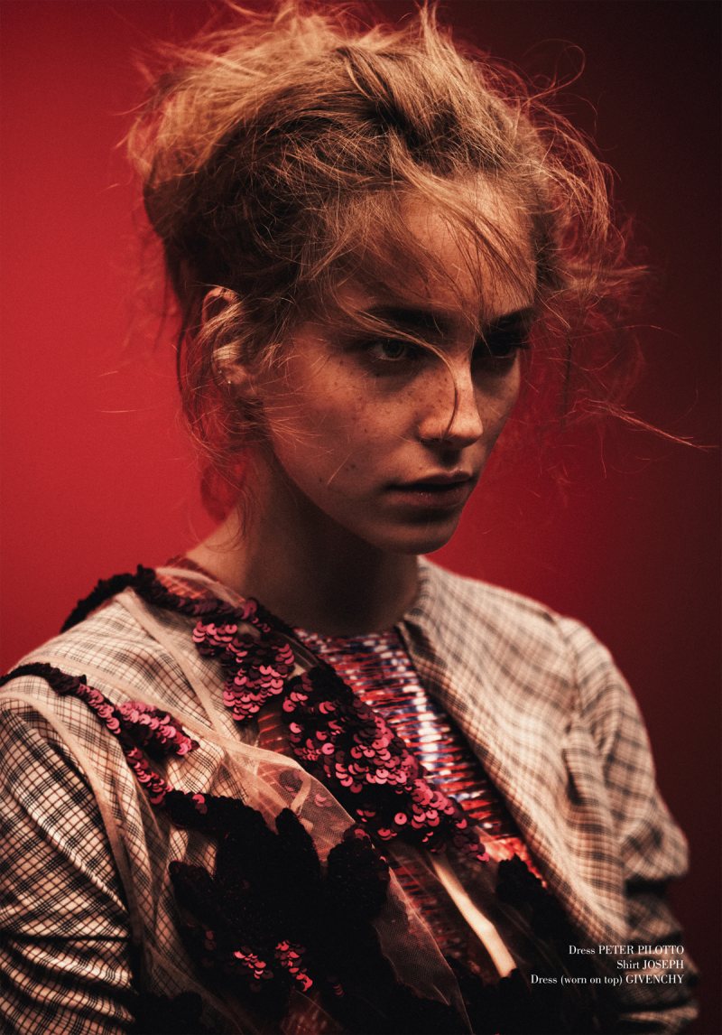 A woman in a red dress is posing for a magazine.