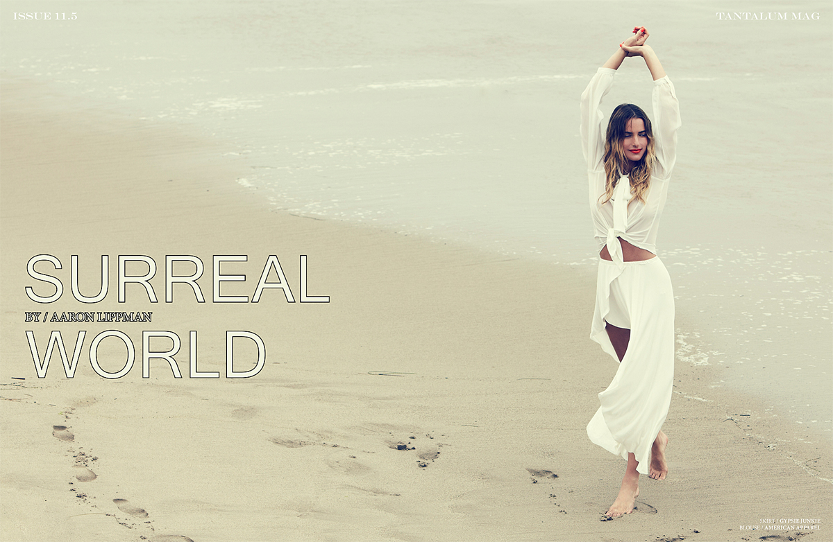 A woman in a white dress standing on the beach.