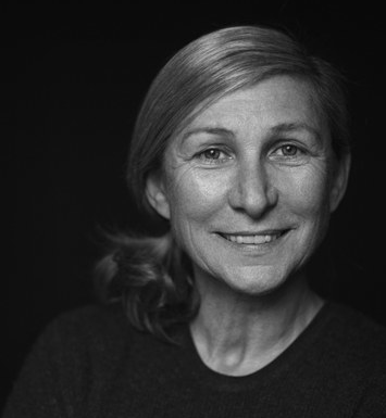 A black and white photo of a woman smiling.