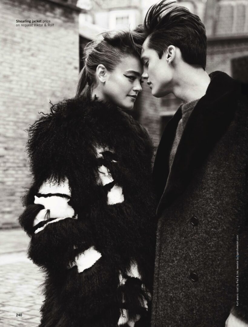 A black and white photo of a couple in a fur coat.