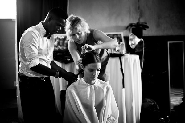 A woman getting her hair done by a man.