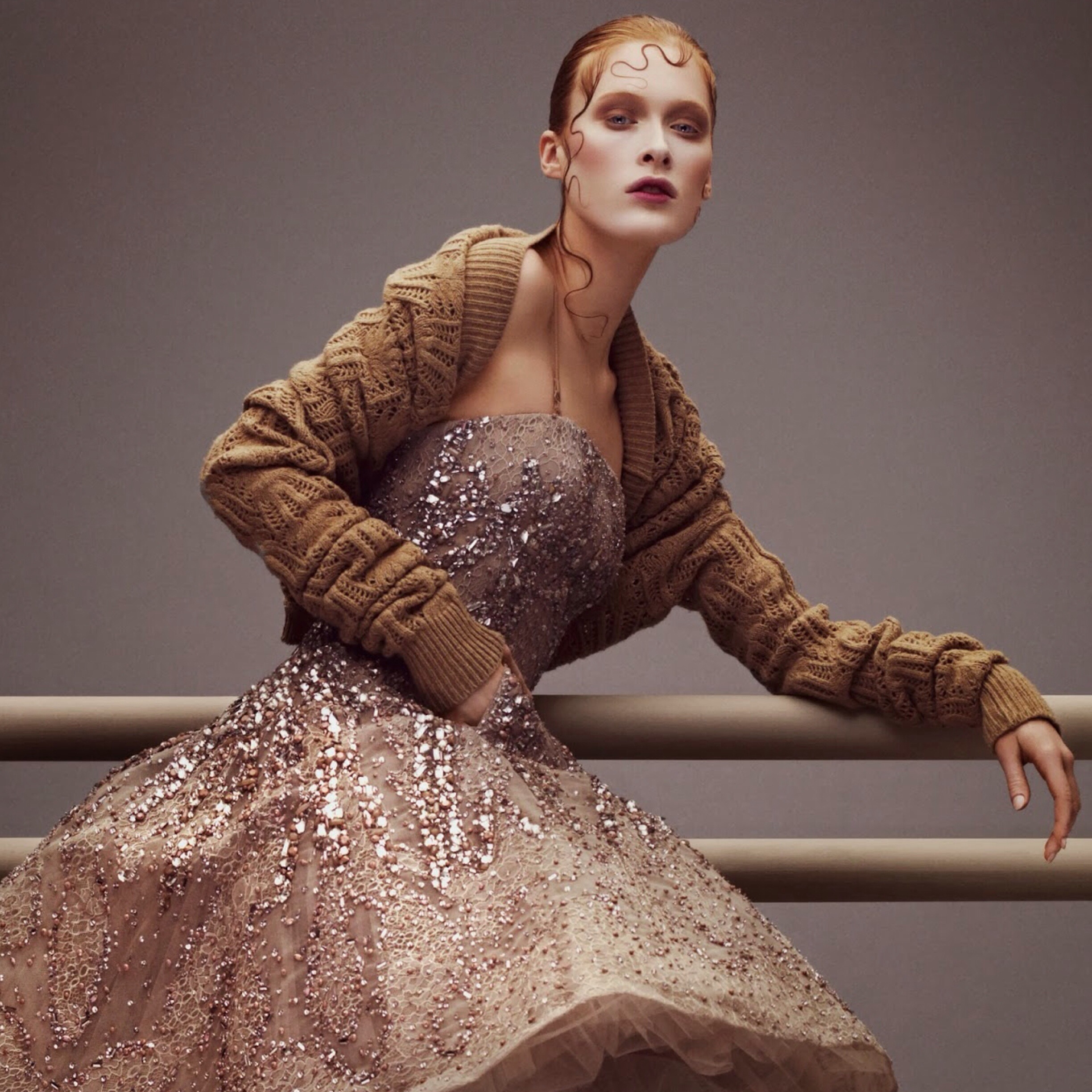 A woman in a sequined dress posing on a railing.