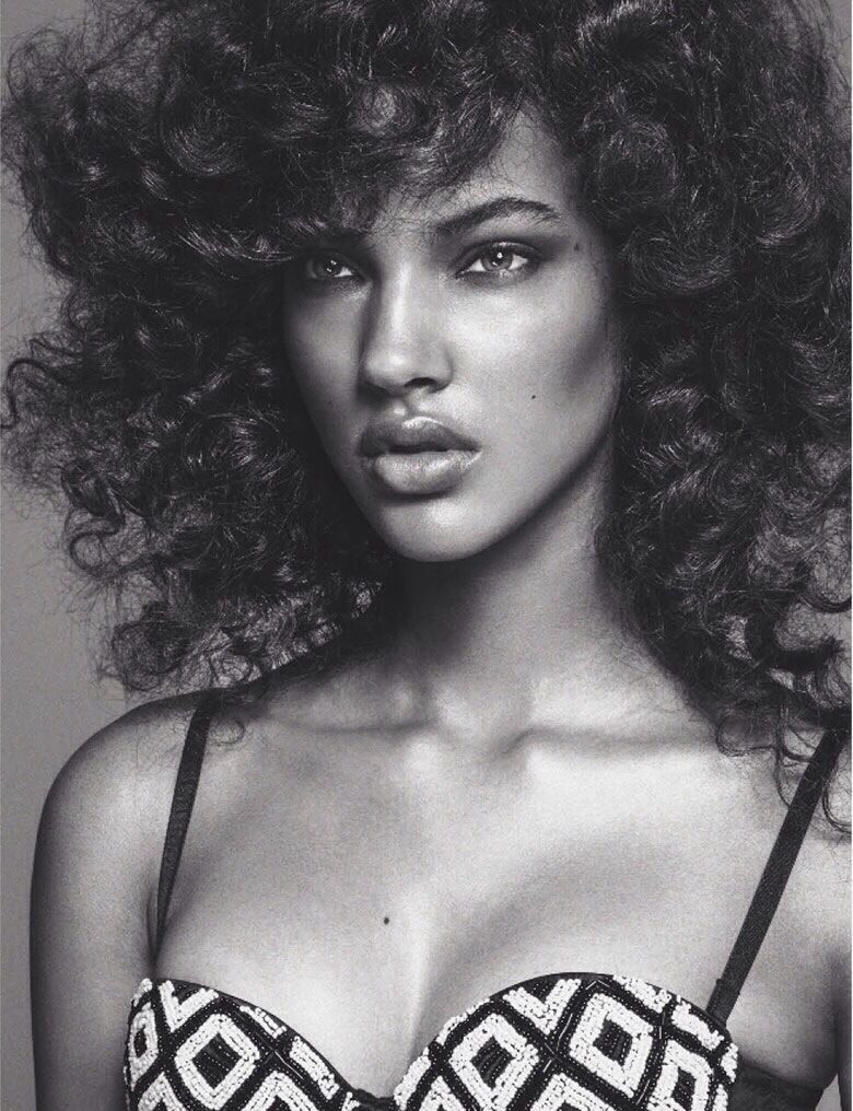 A black and white photo of a woman with curly hair.