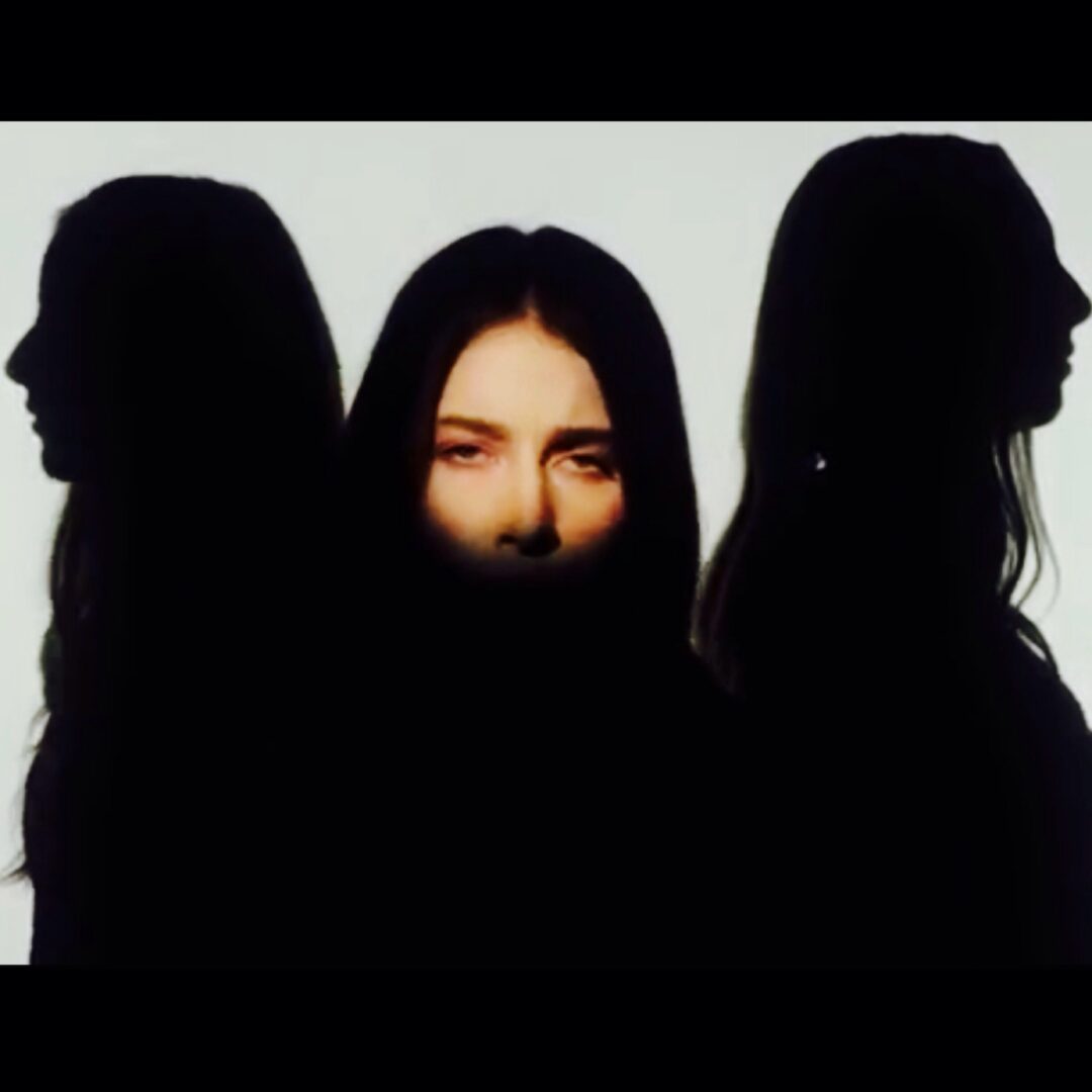 Three silhouettes of women standing in front of each other.