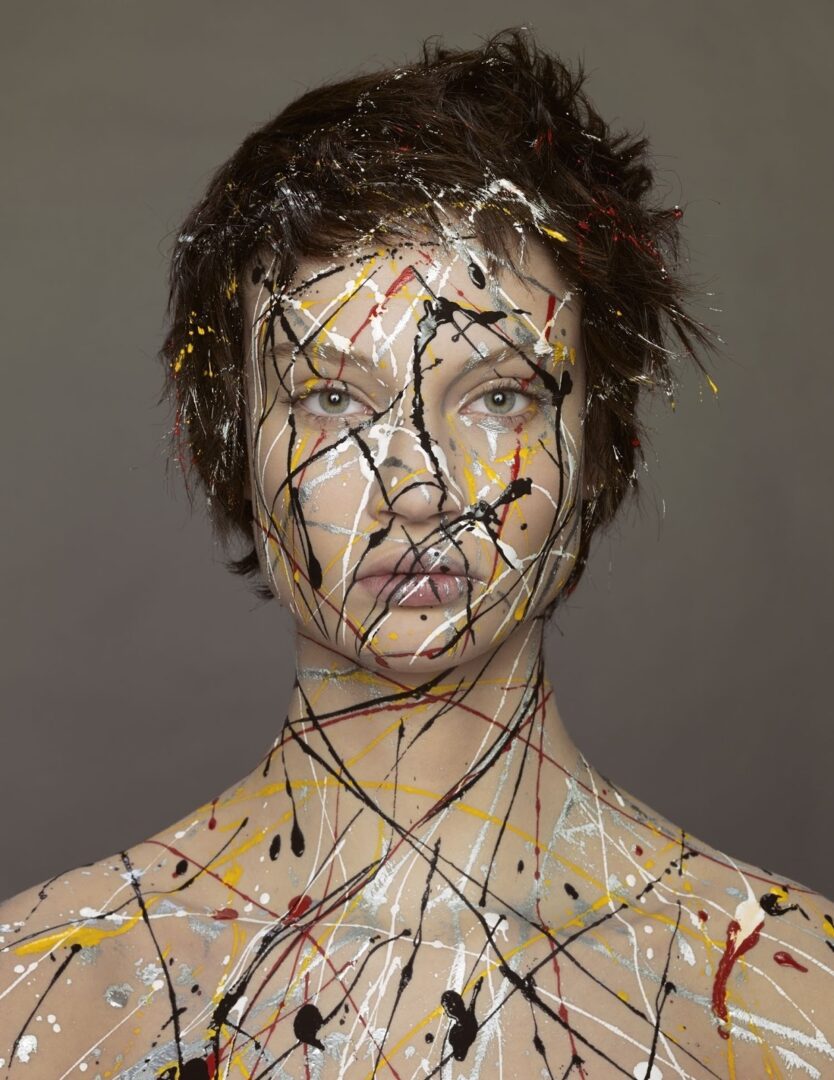 A woman with paint splatters on her face.