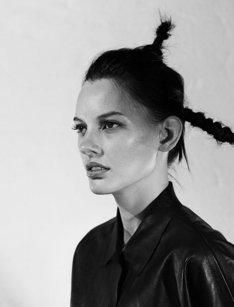 A black and white photo of a woman with braids.