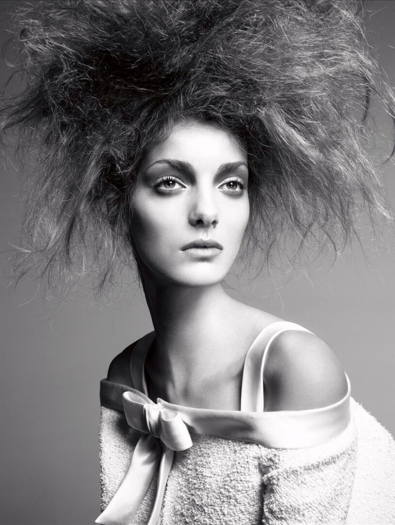 A black and white photo of a woman with big hair.