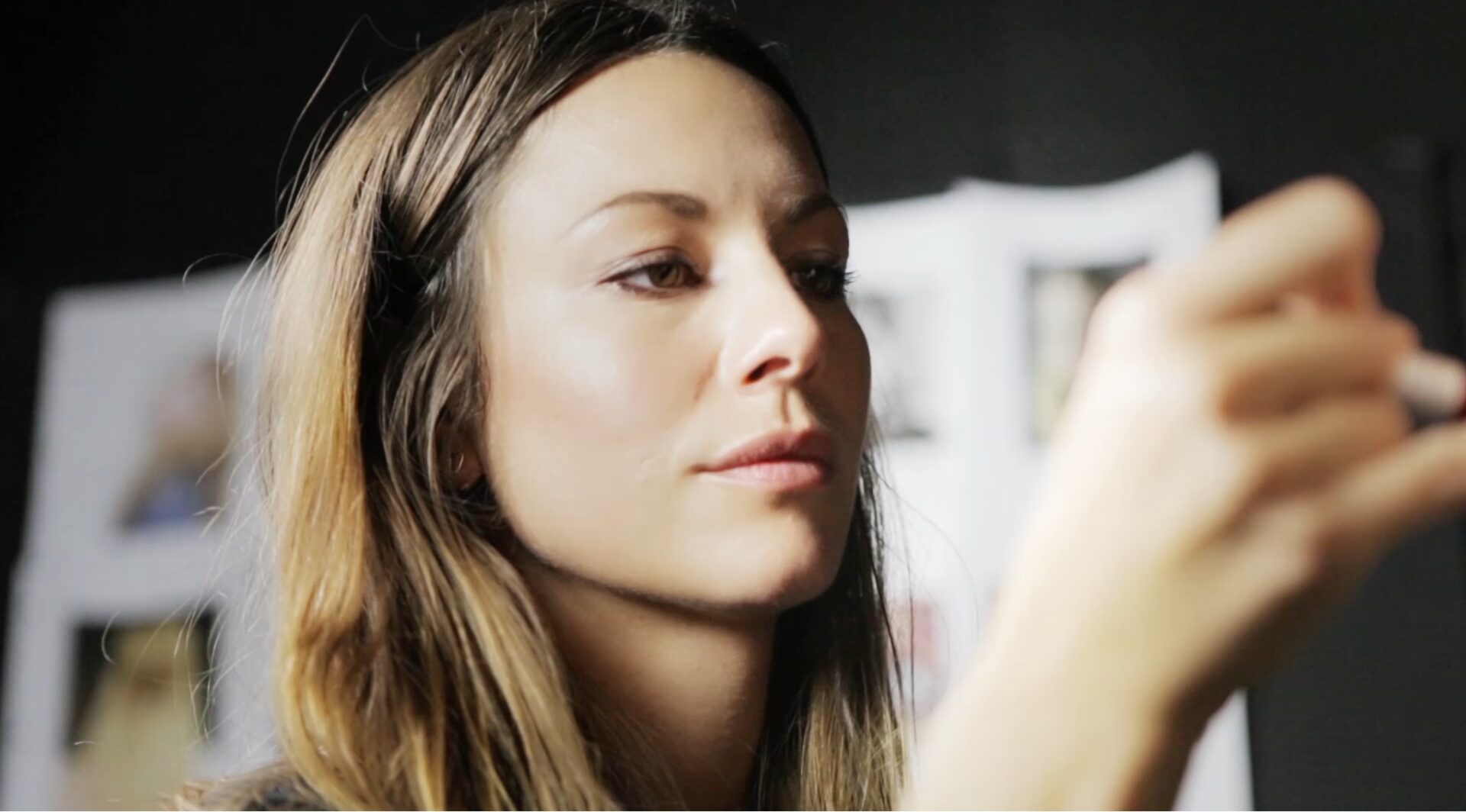 A woman is putting makeup on her face.