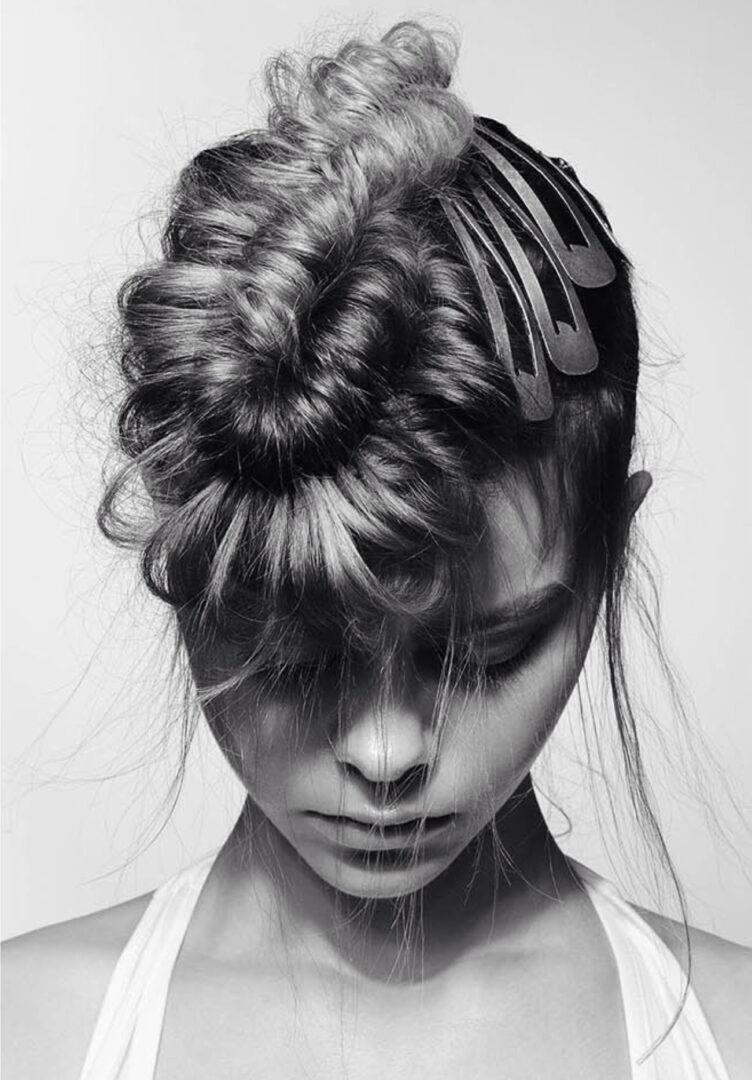 A black and white photo of a woman with a comb in her hair.