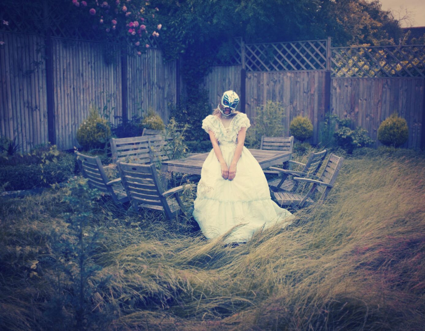 A woman in a wedding dress standing in the grass.