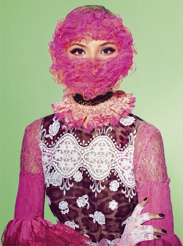 A woman in a pink dress with a pink mask on her face.