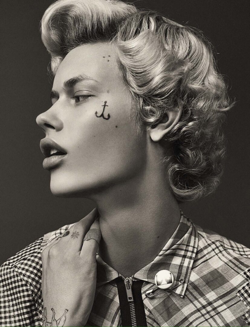 A black and white photo of a woman with tattoos on her face.