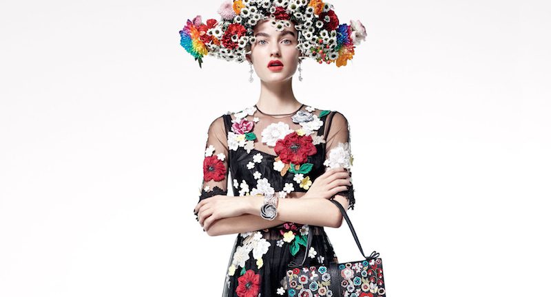 A woman in a black dress with flowers on her head.