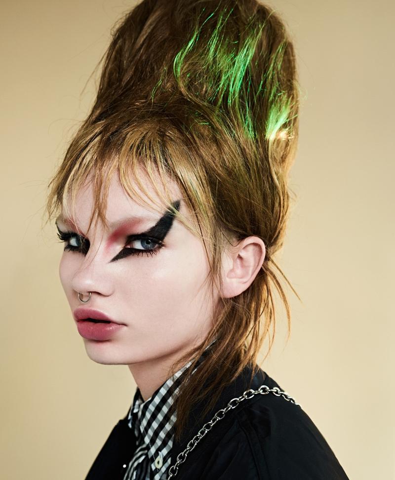 A woman with green eye makeup and a green hairdo.