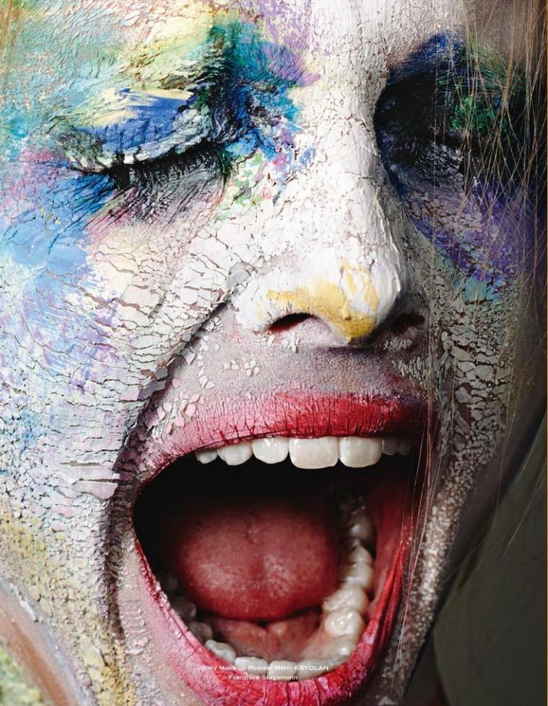 A woman with paint on her face is yelling.