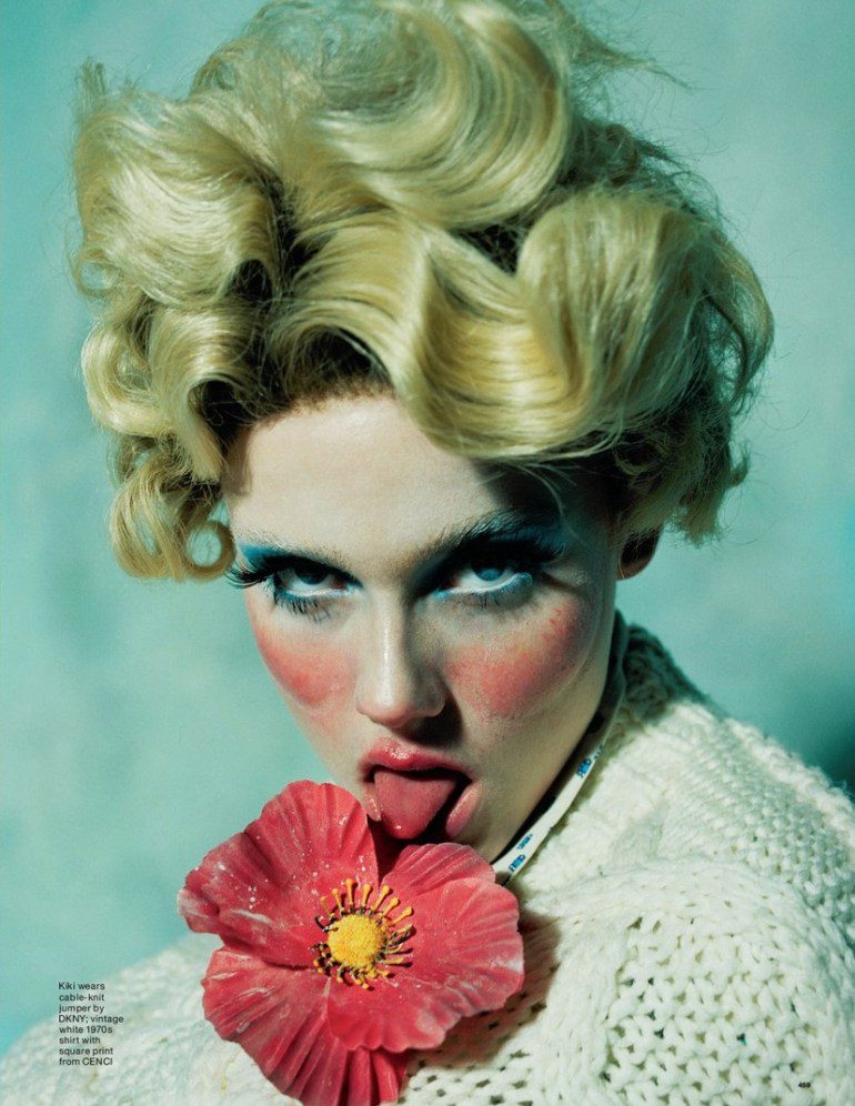 A woman is holding a flower in her mouth.