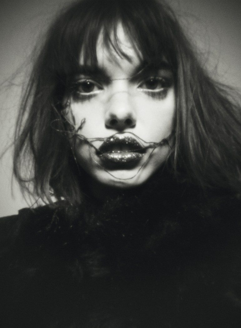 A black and white photo of a woman with makeup on her face.