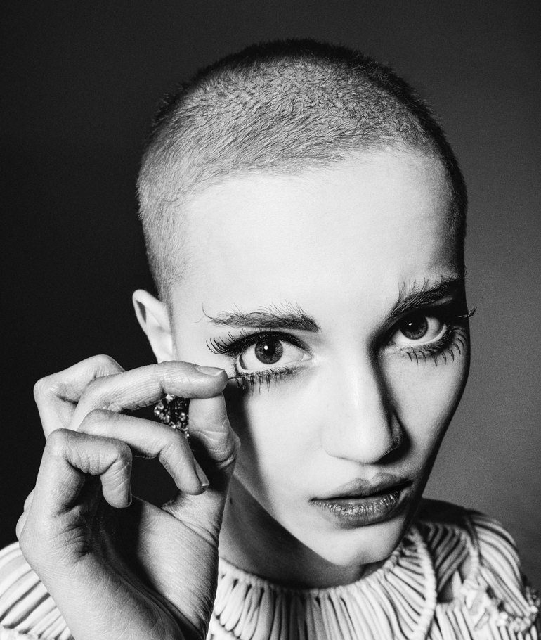 A black and white photo of a woman with a shaved head.