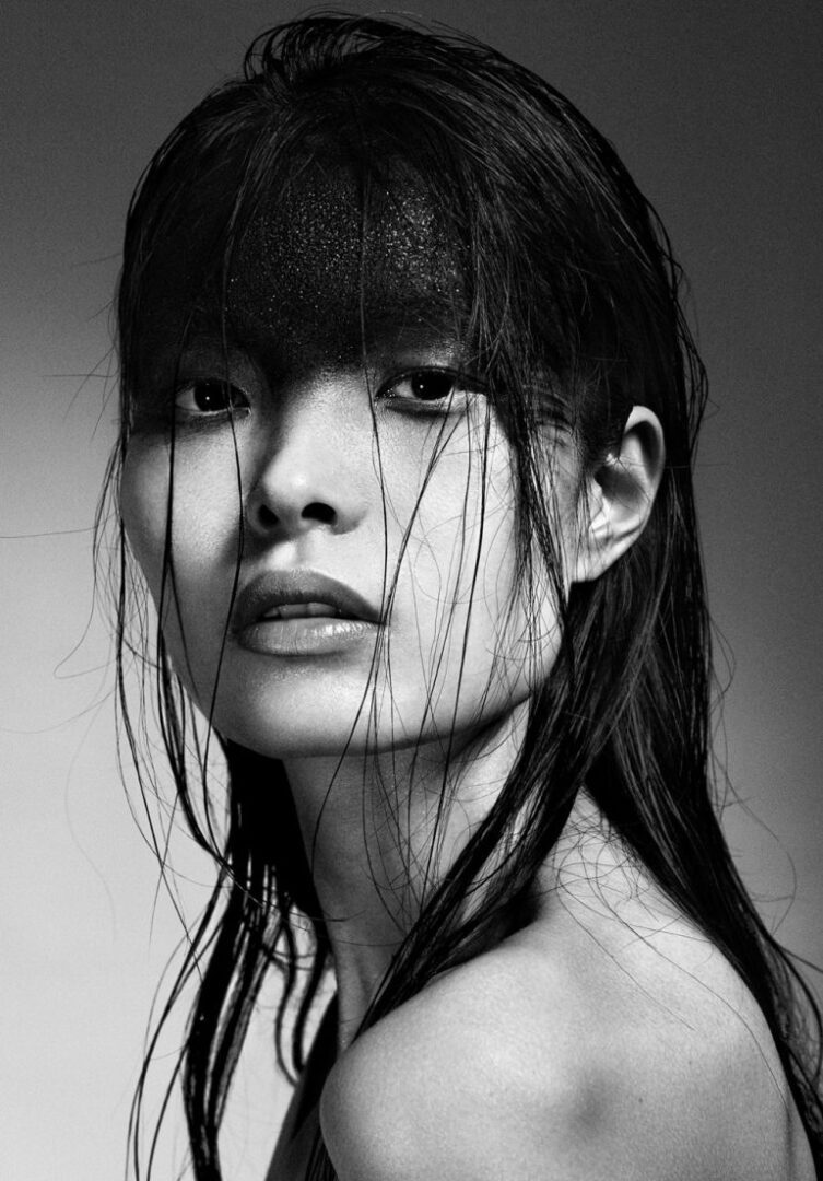 A black and white photo of a woman with wet hair.