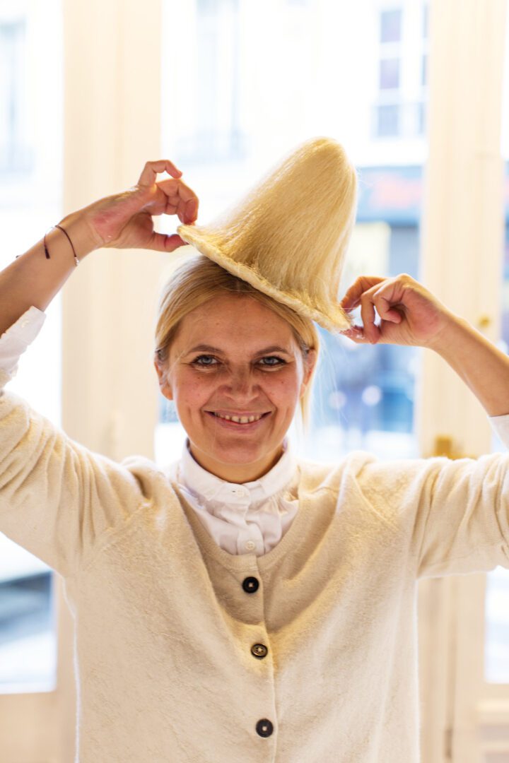 A woman holding a hat.