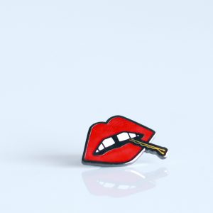 A "Lips" enamel lapel pin by LH™ with a mouth on it.