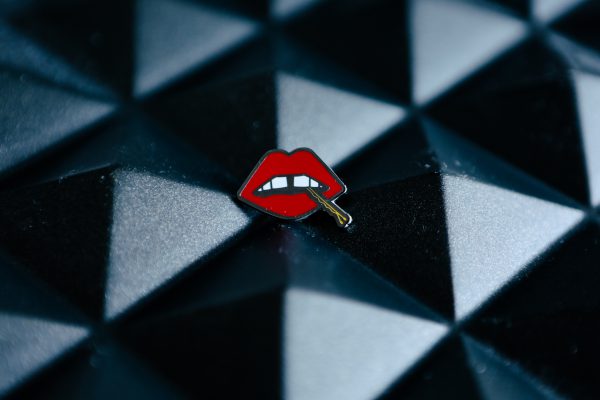 Lips" an enamel lapel pin by LH™ with a red lips on it.